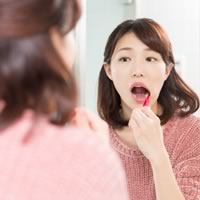 矯正器具を取り外し、歯みがきをする女性